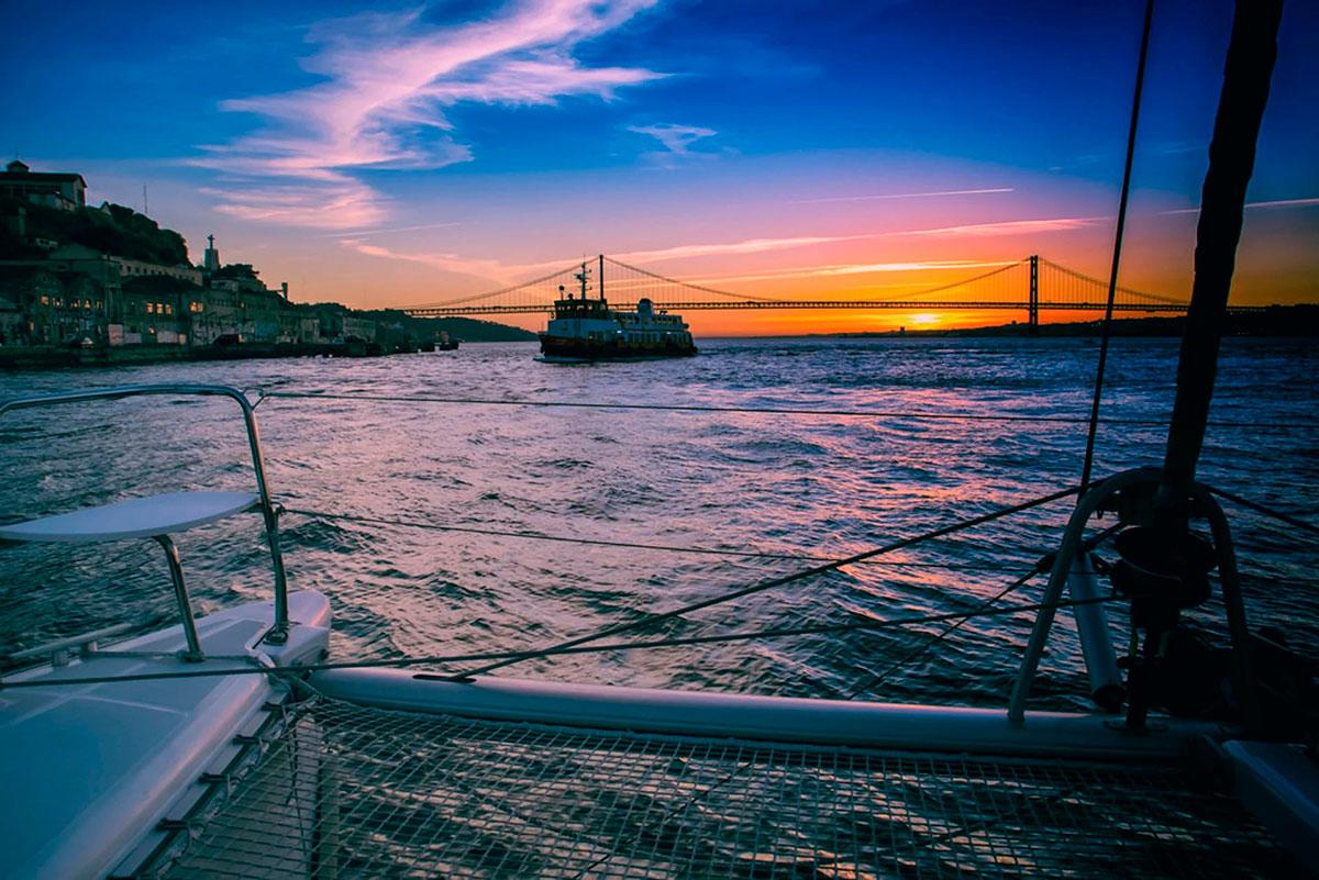 Boat cruising on the Tagus River with sunset in the background