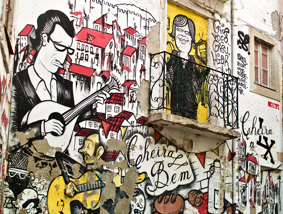 Vibrant street art mural in Lisbon's historic Mouraria district, depicting local culture.