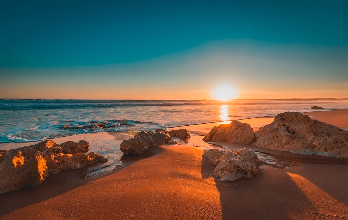 Sunrise casting golden hues over the Algarve coastline
