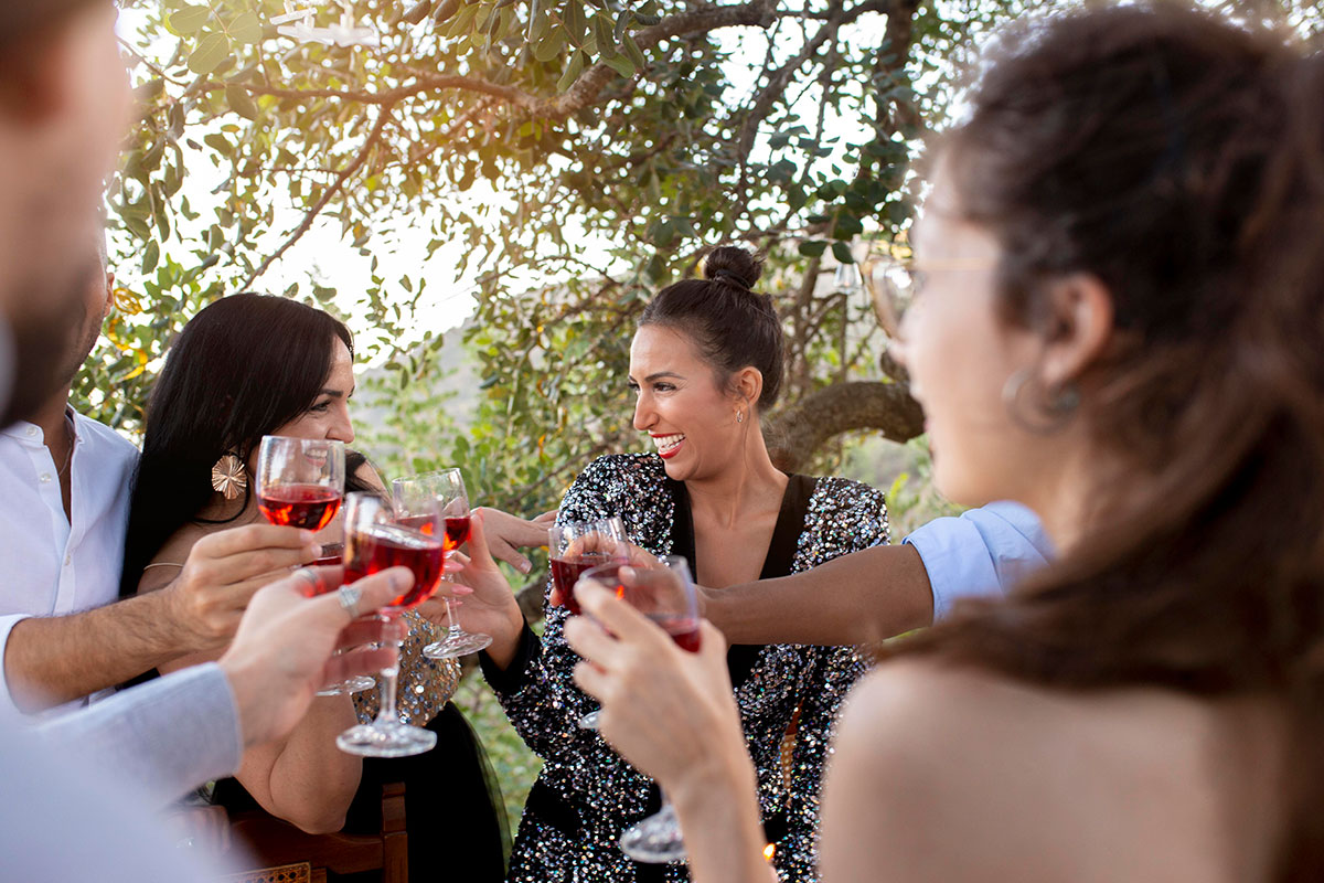 Visitors enjoying a guided wine tasting session at an Alentejo vineyard, with glasses and bottles arranged on a rustic table.