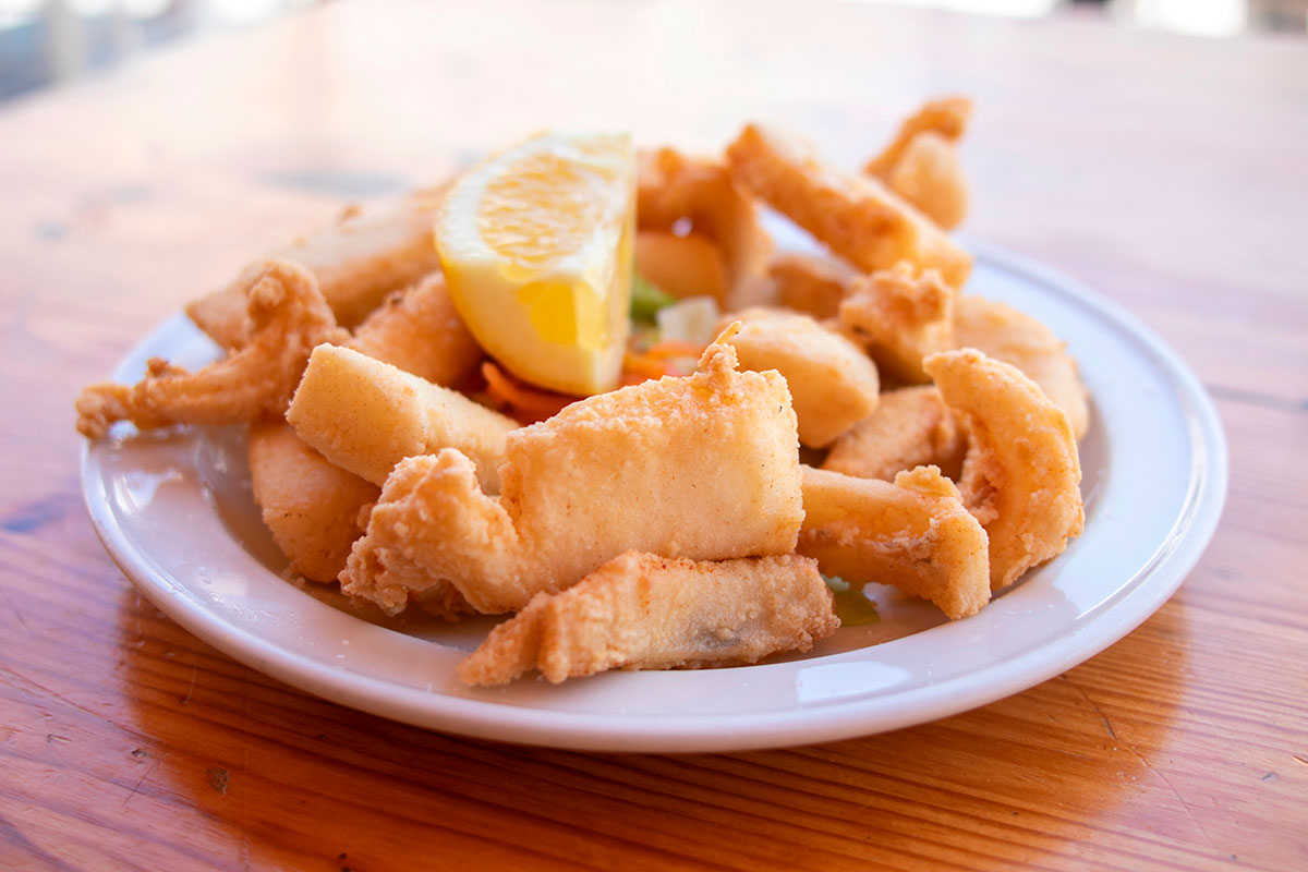 Plate of Choco Frito served with fries and salad in Setúbal.