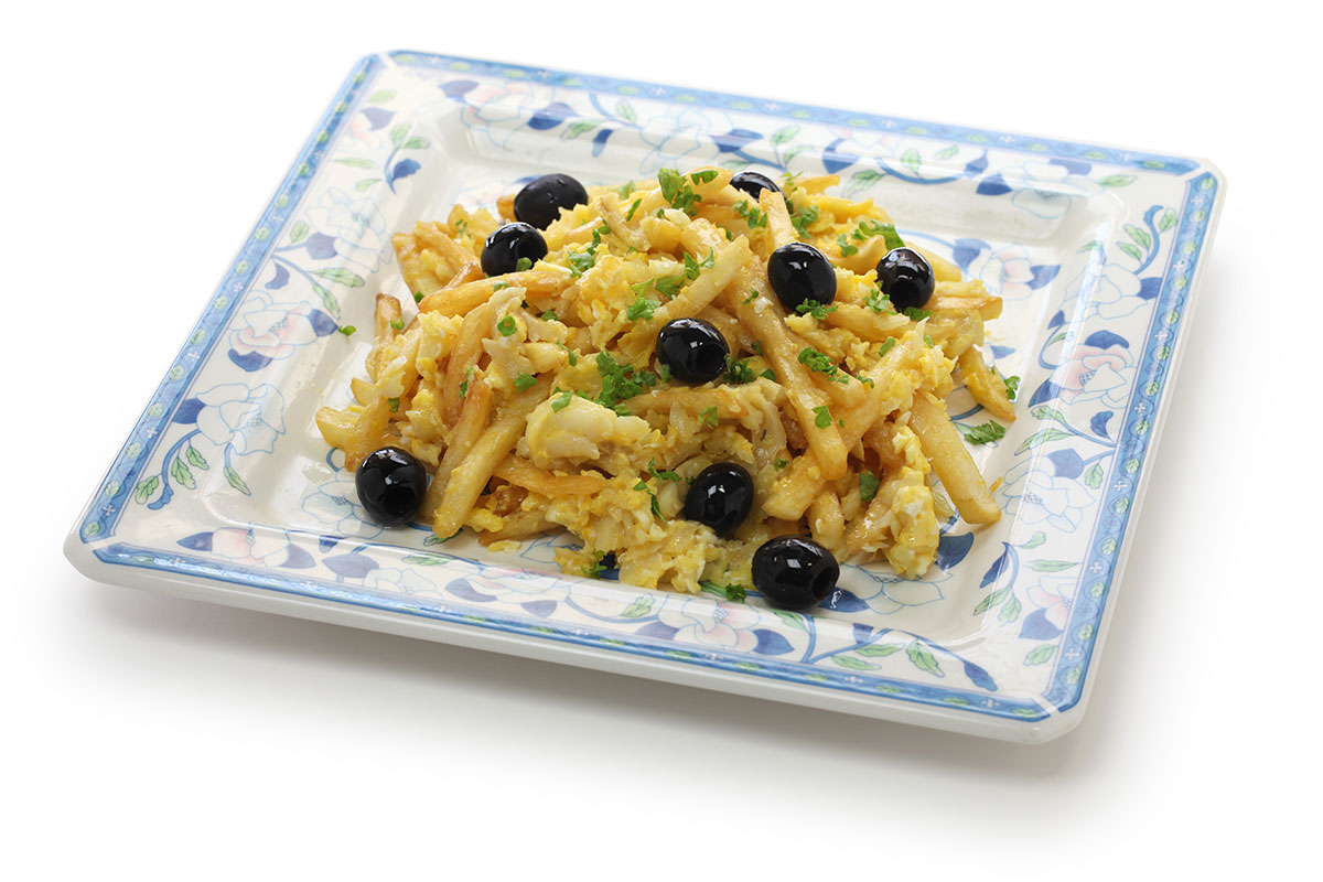 Bacalhau à Brás topped with black olives and parsley.