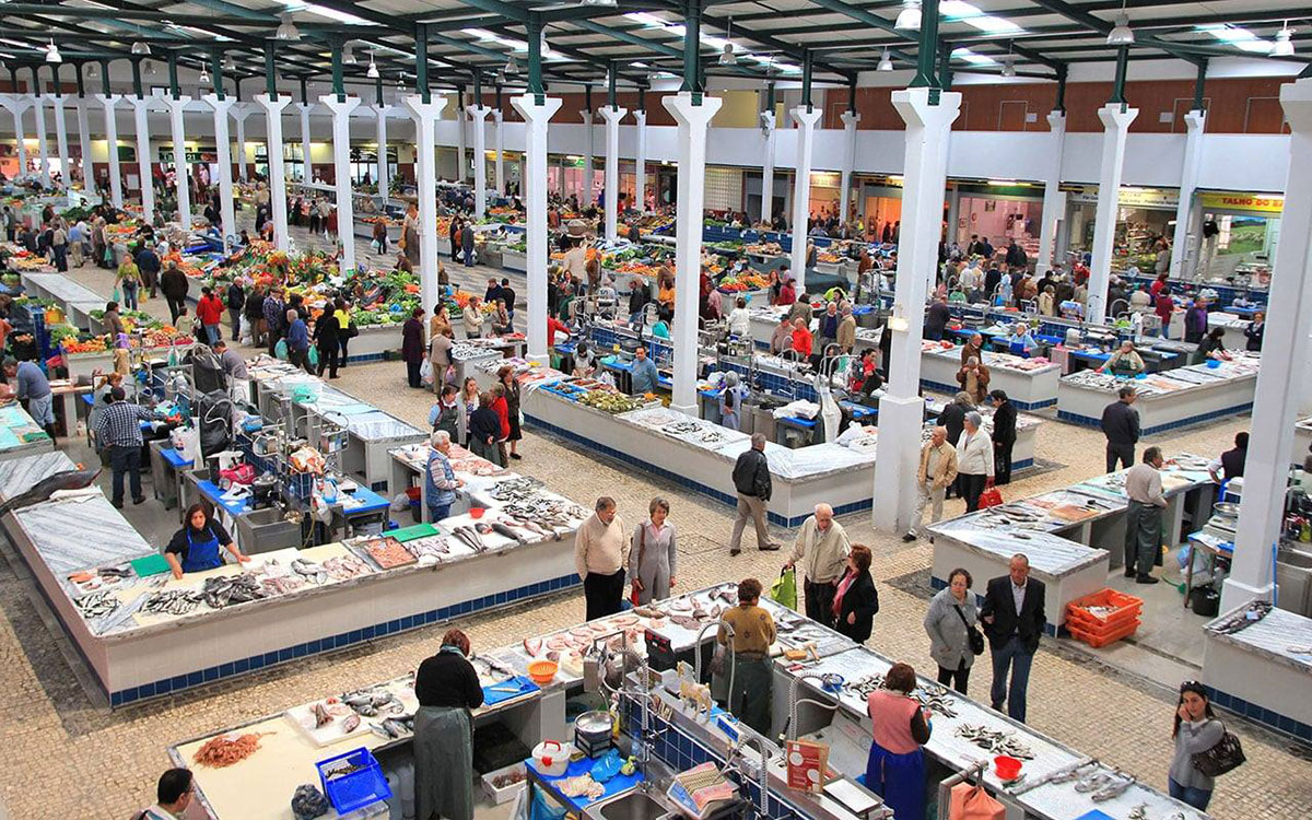 Interior of Mercado do Livramento bustling with seafood vendors.