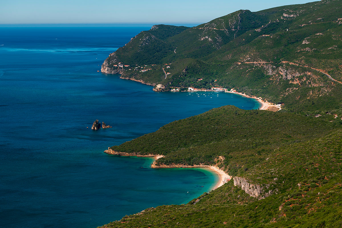 Aerial view of Arrábida Natural Park's coastline with turquoise waters.