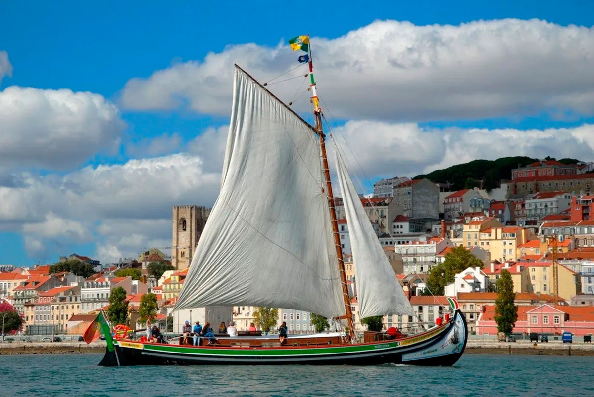 Historic Canoa boat sailing on the Tagus River in Lisbon