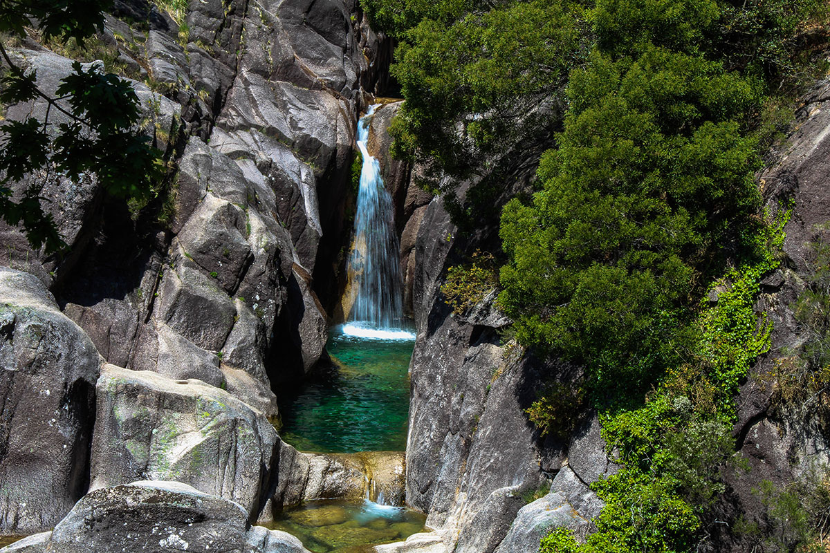 The cascading waters of Cascata do Arado amidst rocky cliffs.