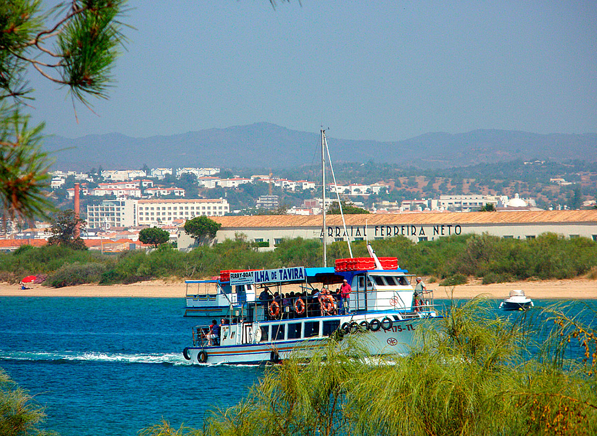 Tourists enjoying a boat tour through the serene waters of Ria Formosa, surrounded by natural beauty.