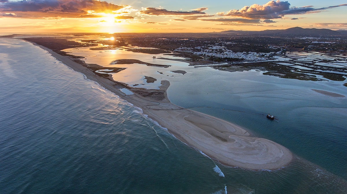 A breathtaking sunset casting golden hues over the waters of Ria Formosa.