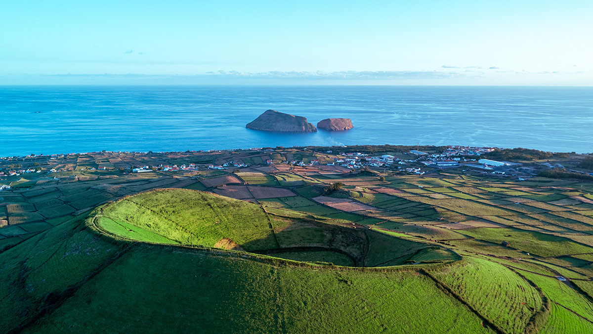 Aerial view of Terceira Island showcasing green pastures and coastline.
