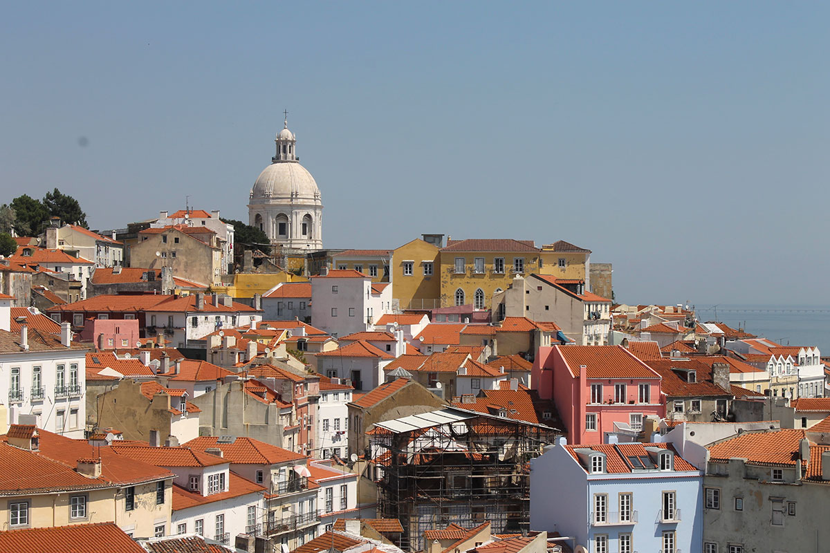 Panoramic view of Alfama's terracotta rooftops and narrow alleys in Lisbon.