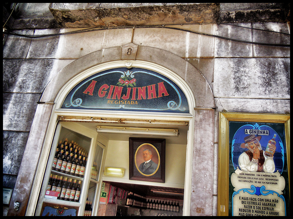 Street view of A Ginjinha bar near Rossio Square, with locals and tourists gathered outside sipping cherry liqueur.