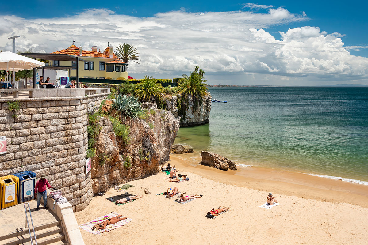 Small beach surrounded by cliffs and historic buildings