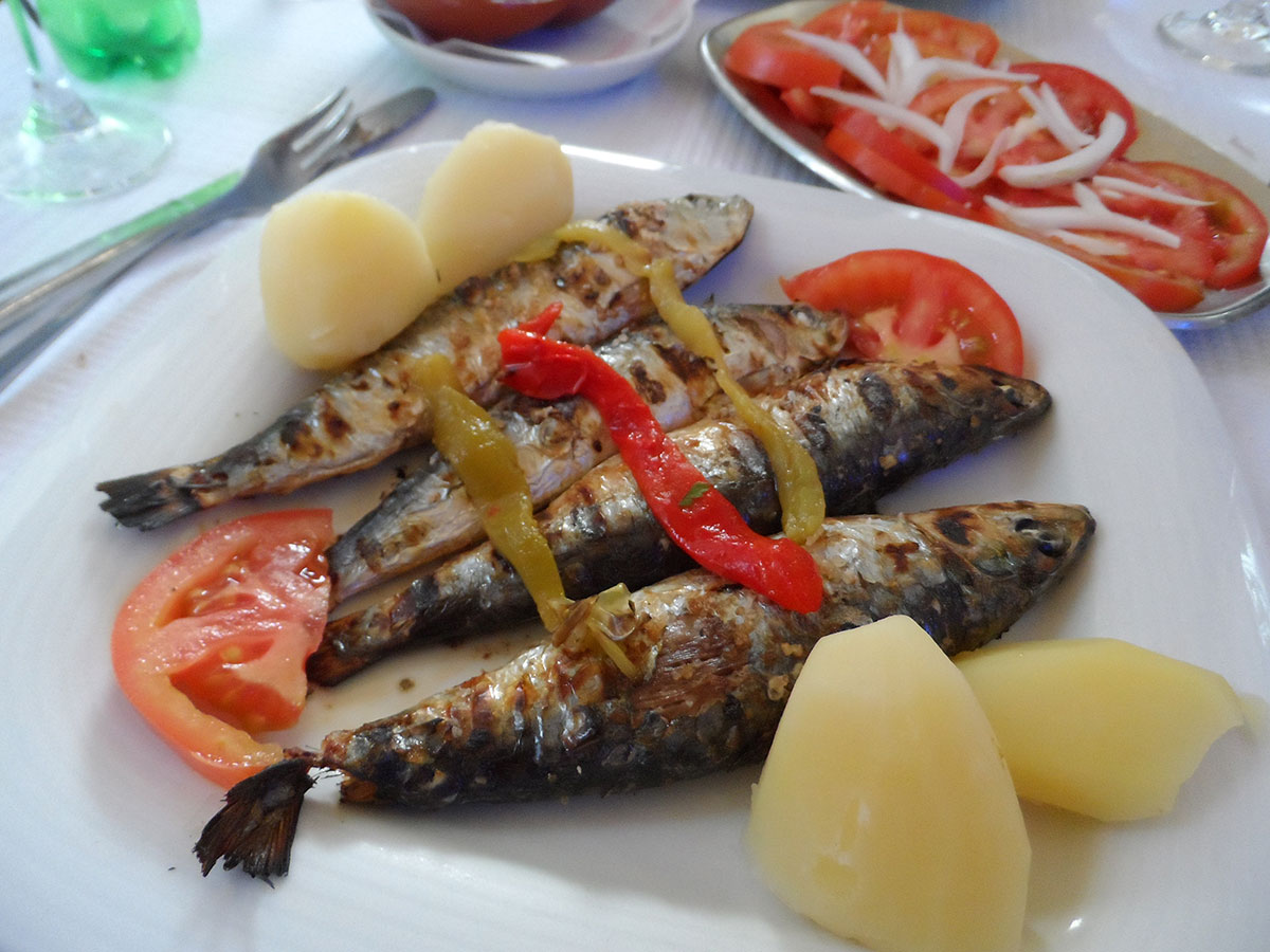 Plate of grilled sardines with salad and lemon