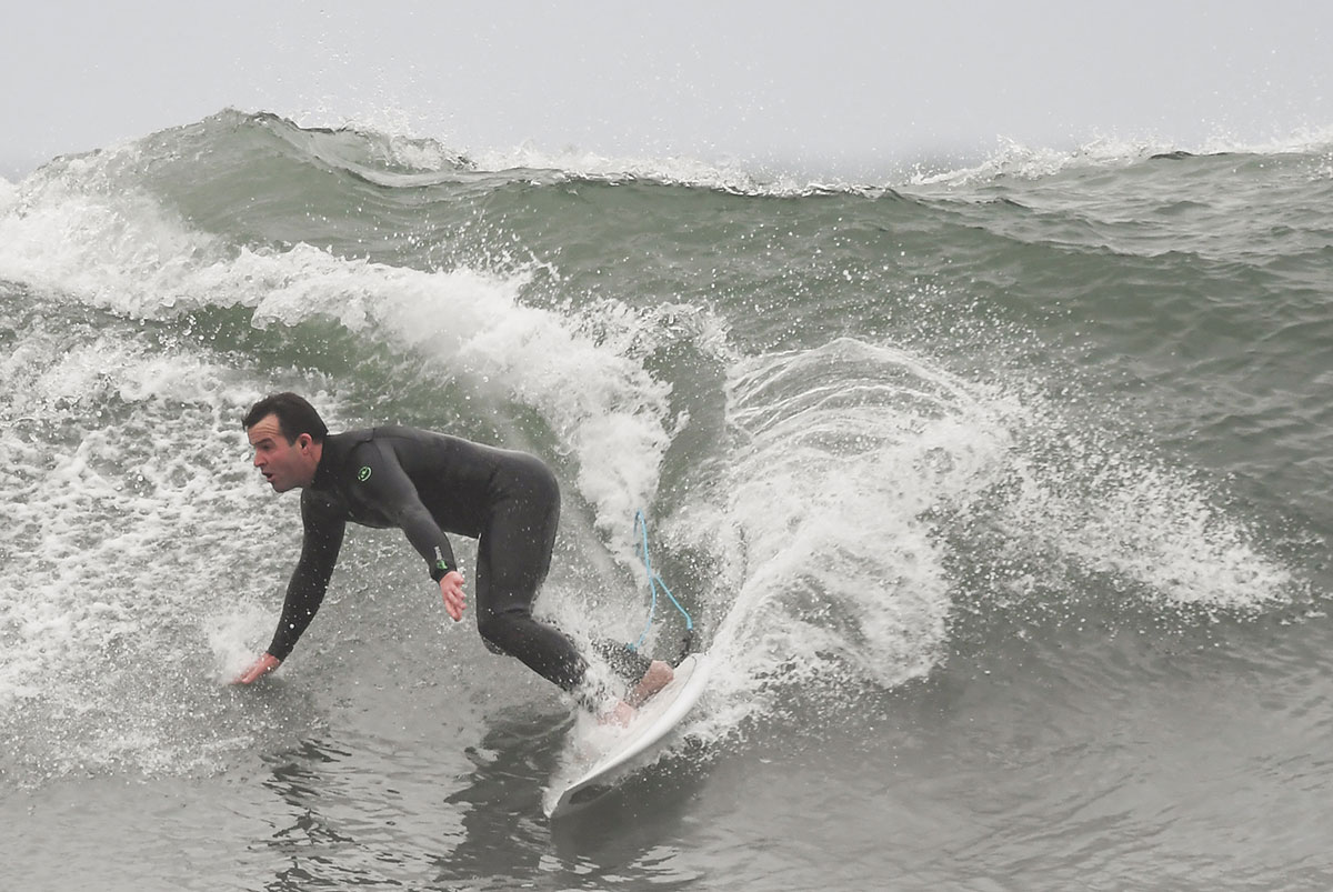 Surfers riding waves at Ribeira d’Ilhas beach in Ericeira