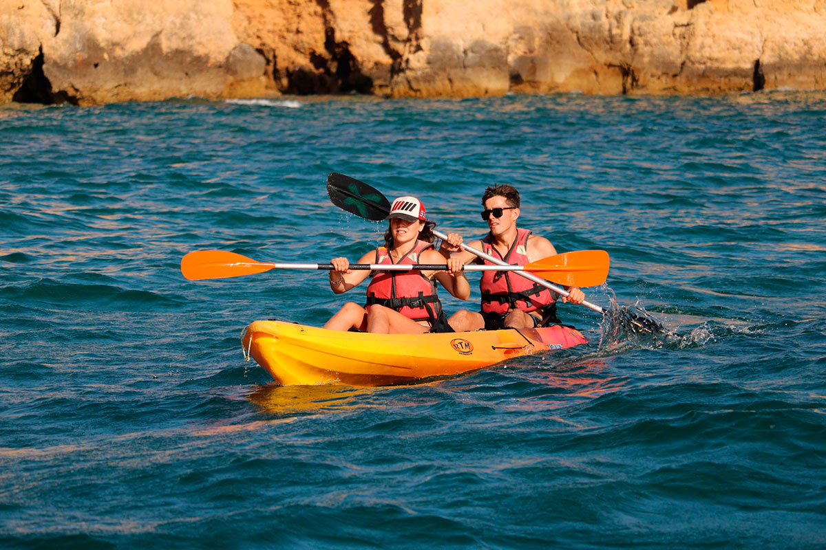 Tourists kayaking through sea caves at Ponta da Piedade