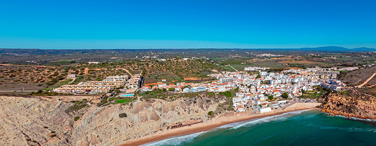 Aerial view of Burgau village nestled between cliffs and the Atlantic Ocean