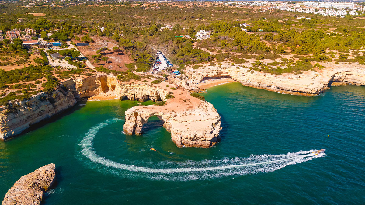 Panoramic view of the Algarve coastline with golden cliffs and turquoise sea.