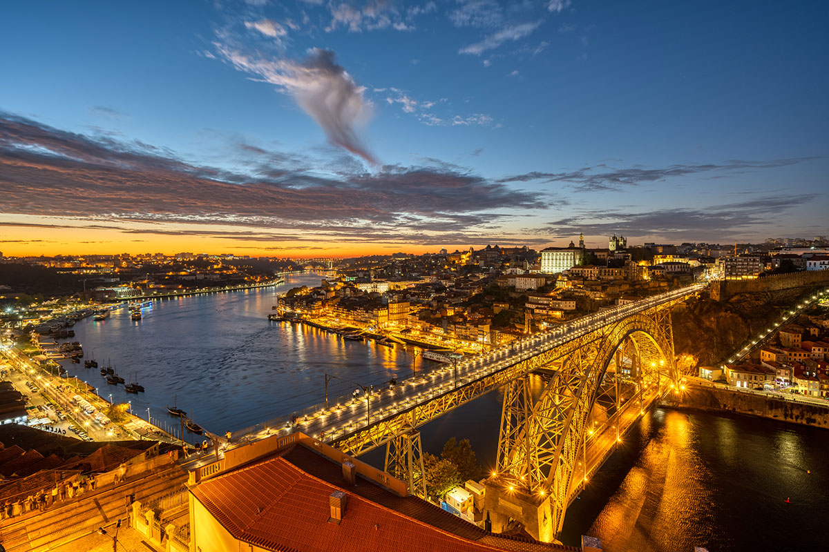 Dom Luís I Bridge illuminated at sunset over the Douro River