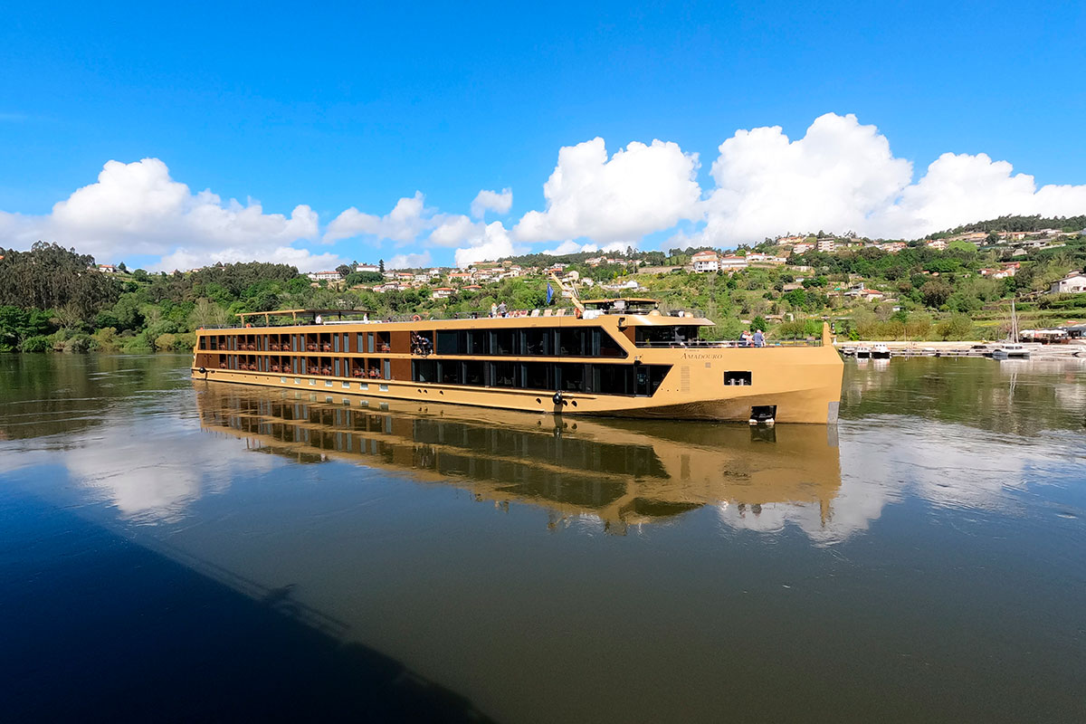 Tour boat cruising along the Douro River with Porto's skyline in the background
