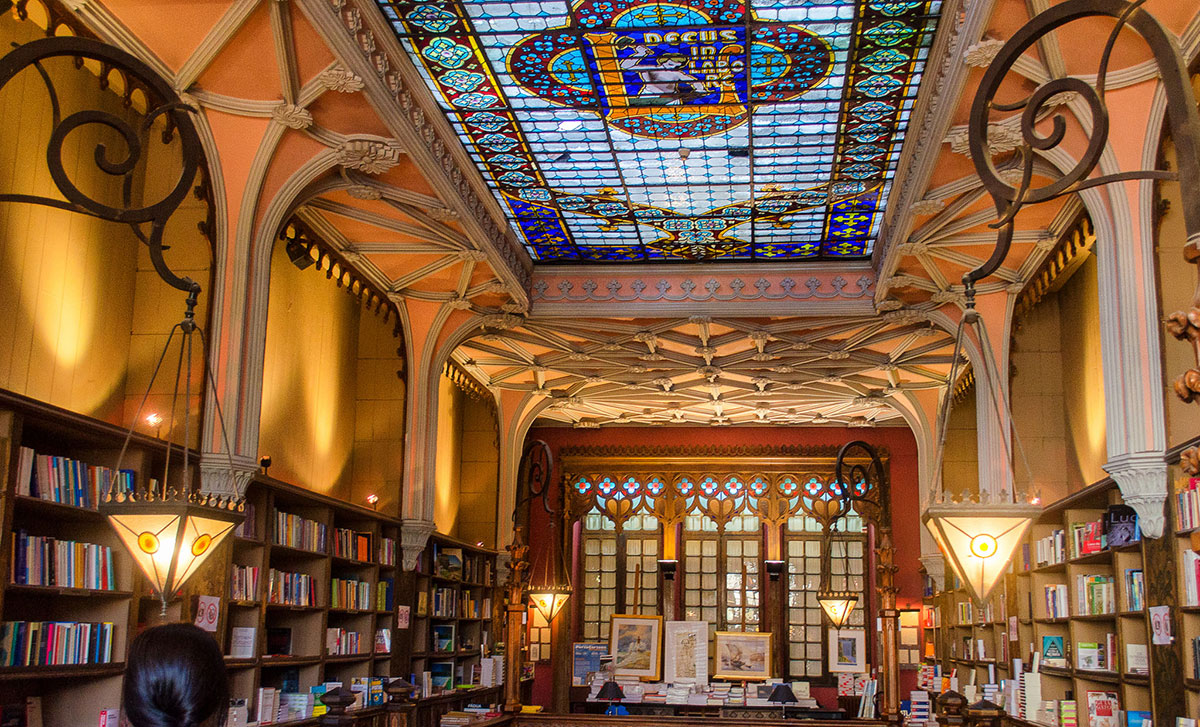 Interior view of Livraria Lello with its grand staircase and stained glass ceiling