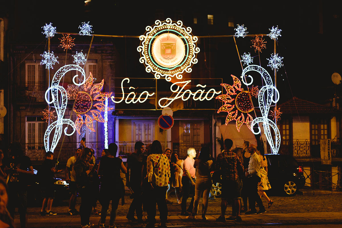 Crowds celebrating São João Festival with lanterns and fireworks in Porto