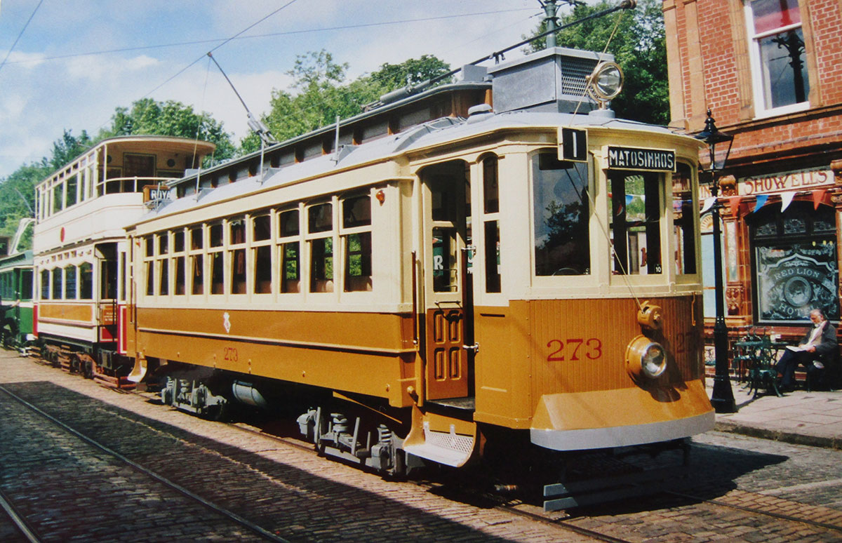 Modern Porto Metro train alongside a historic tram on city streets