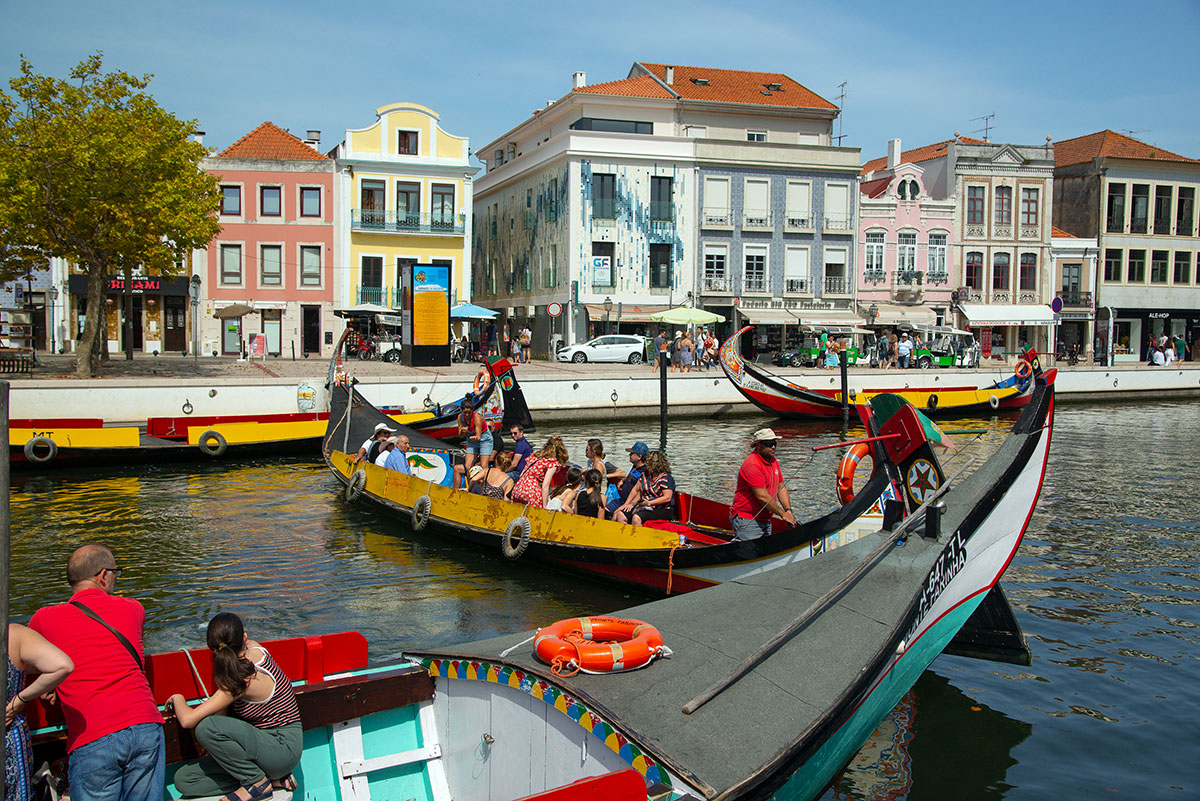 Colorful Moliceiro boats navigating the canals of Aveiro, Portugal.