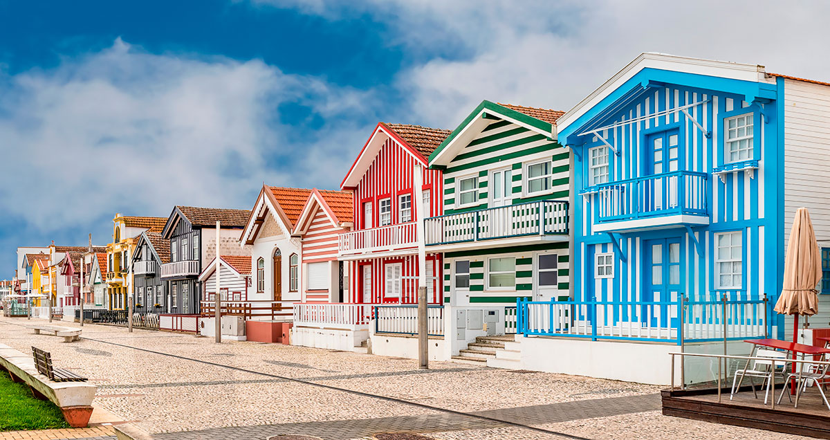 Vibrantly colored striped houses, known as Palheiros, in Costa Nova, Portugal.
