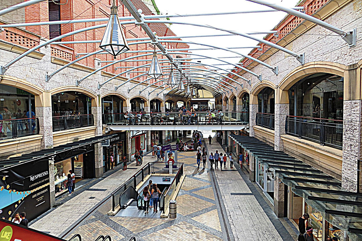 Open-air Forum Aveiro shopping center with canal-side views and modern architecture.