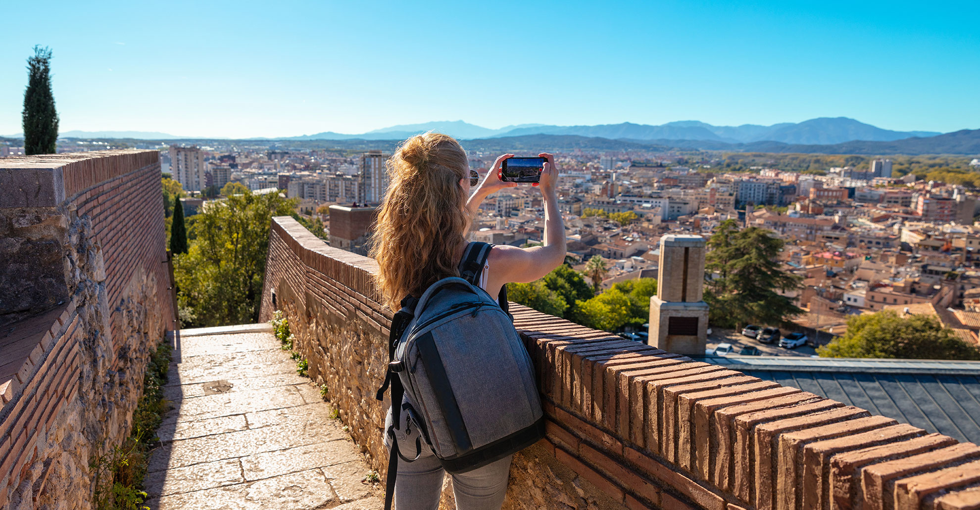 Woman-tourist-taking-photography-at-Girona,-panoramic-view-of-the-city--Spain
