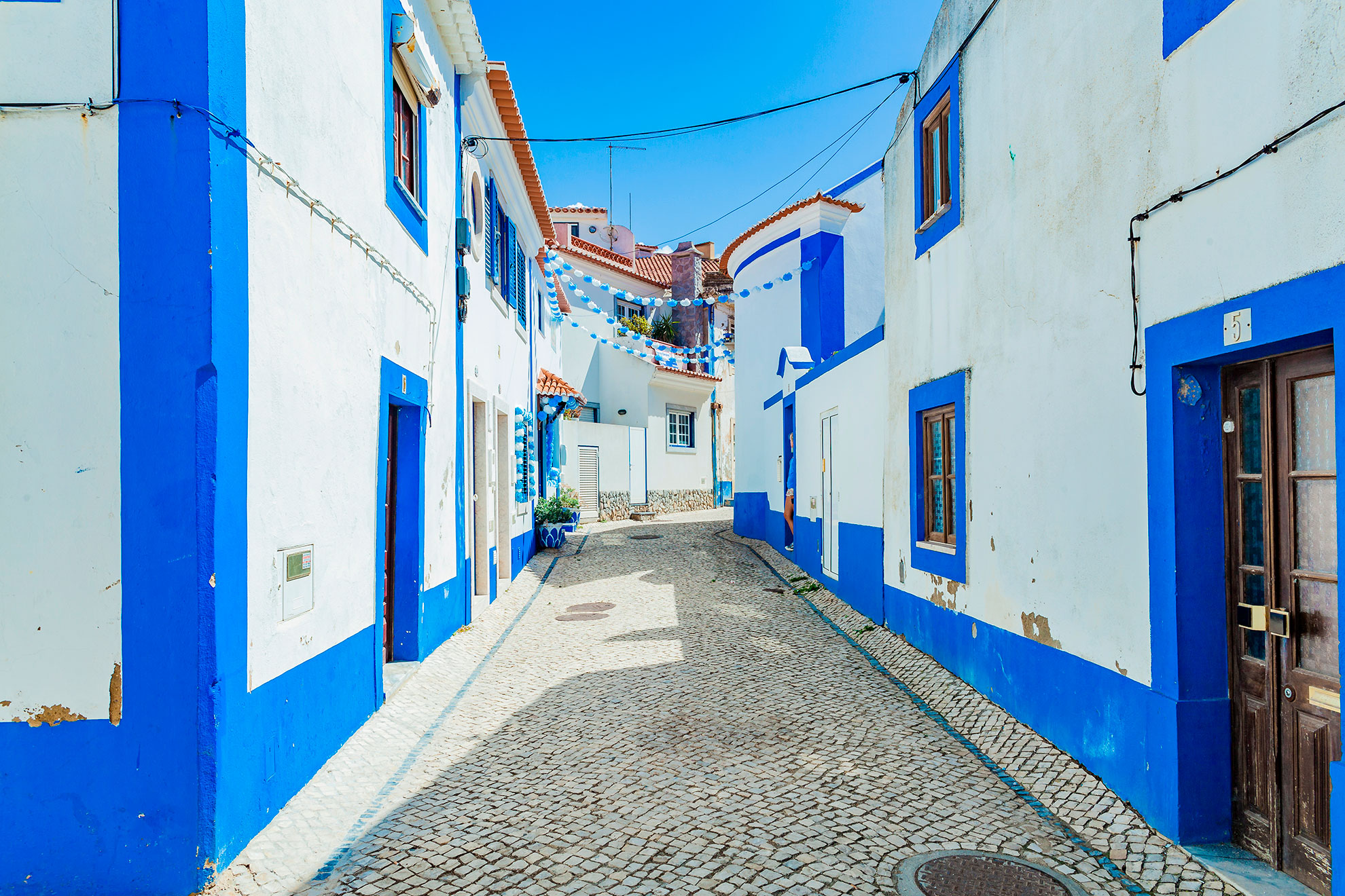 Picturesque streets in the tiny Portuguese ocean village Ericeira, Portugal. Blue streets. Travel to the sea