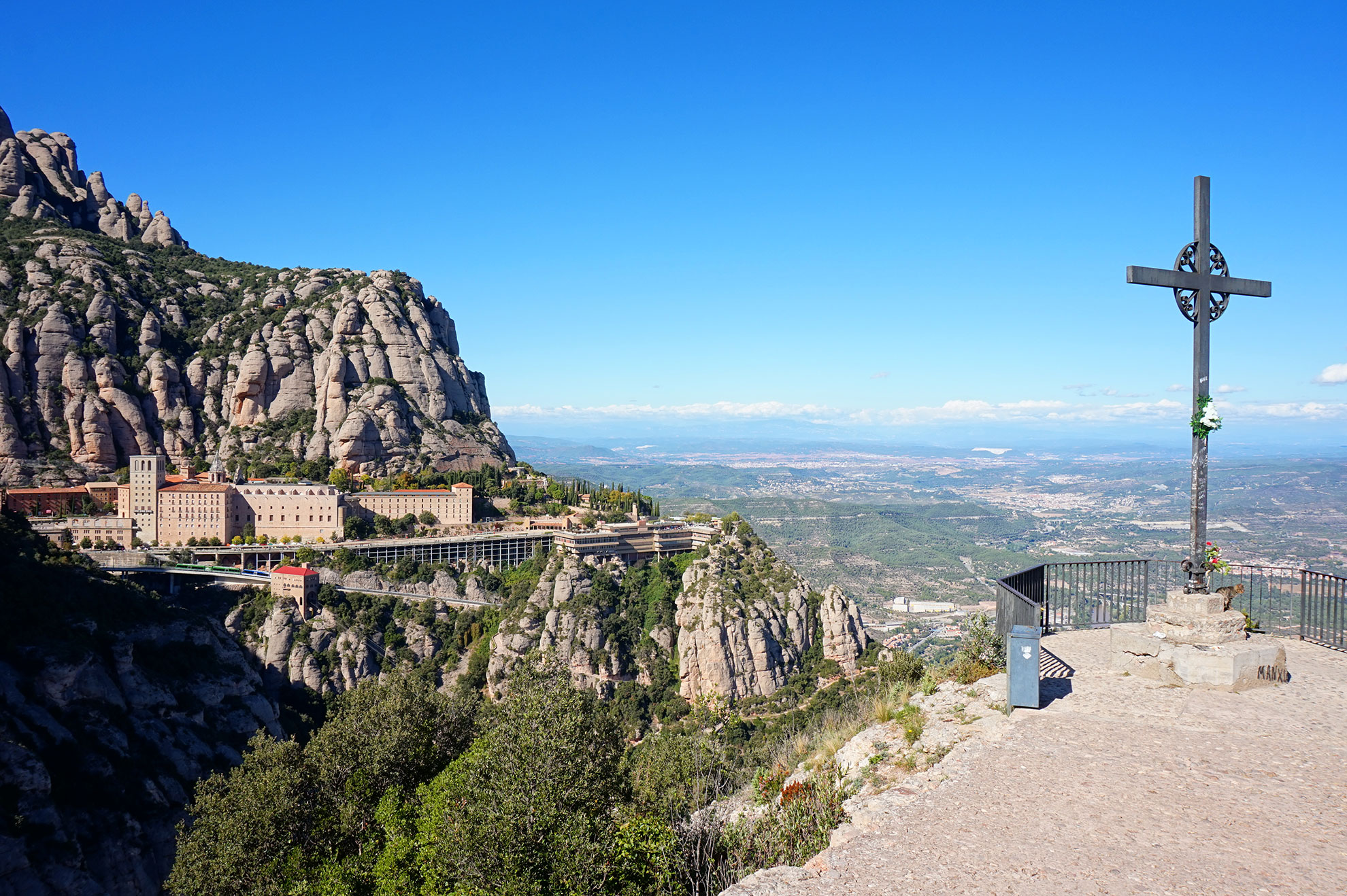 Panoramic landscape of Montserrat Monastery from the Creu de Sant Miquel cross viewpoint, overlooking the vast Catalan countryside in Spain