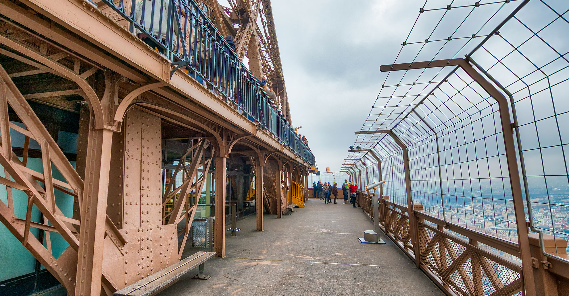PARIS - DECEMBER 2012: Tourists on the top of Eiffel Tower. The city attracts 40 million tourists every year