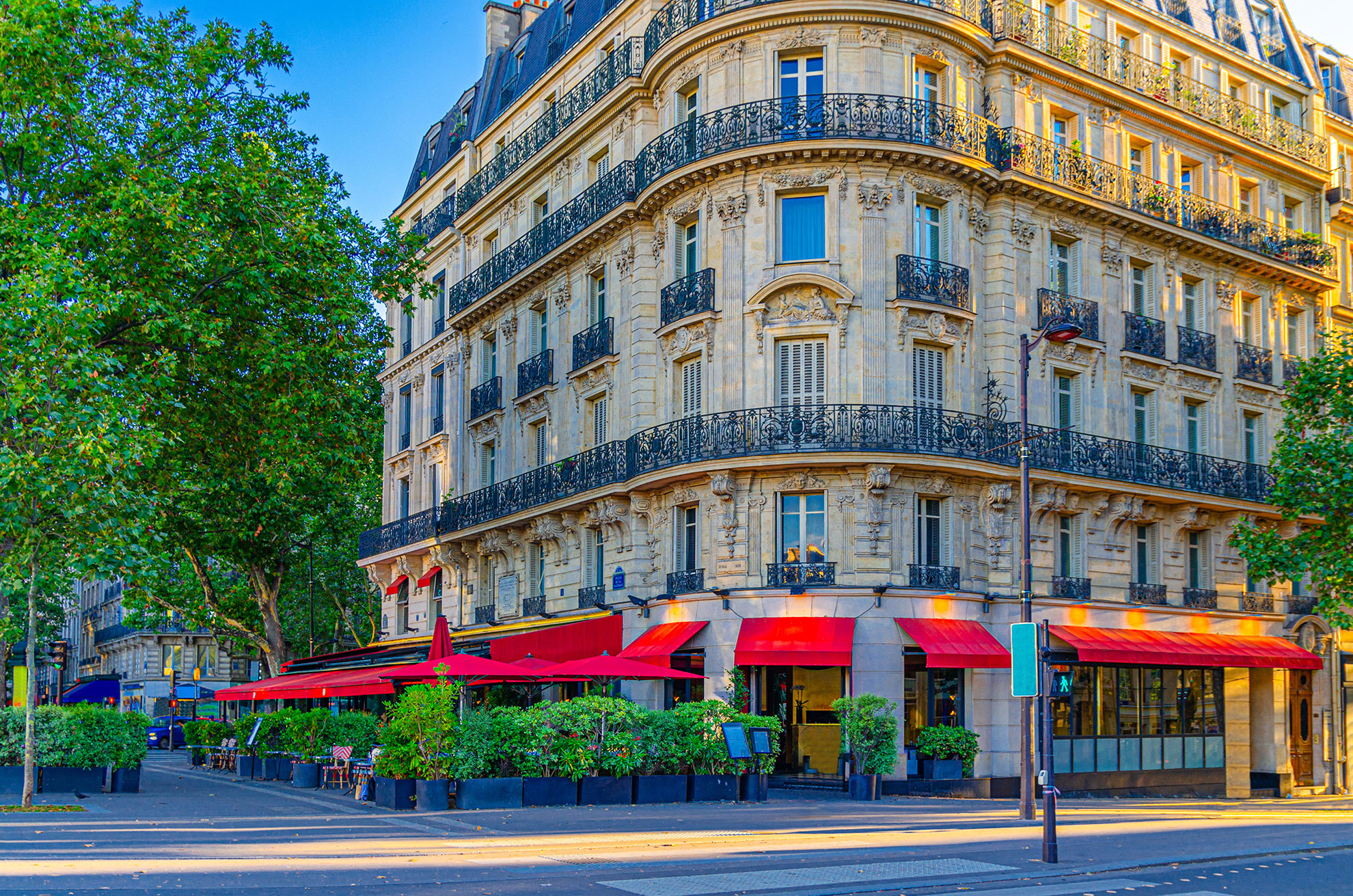 Paris city with street cafe restaurant on boulevard, traditional Parisian architecture apartment building with typical facade, balconies and windows iron fences in Le Marais historic district