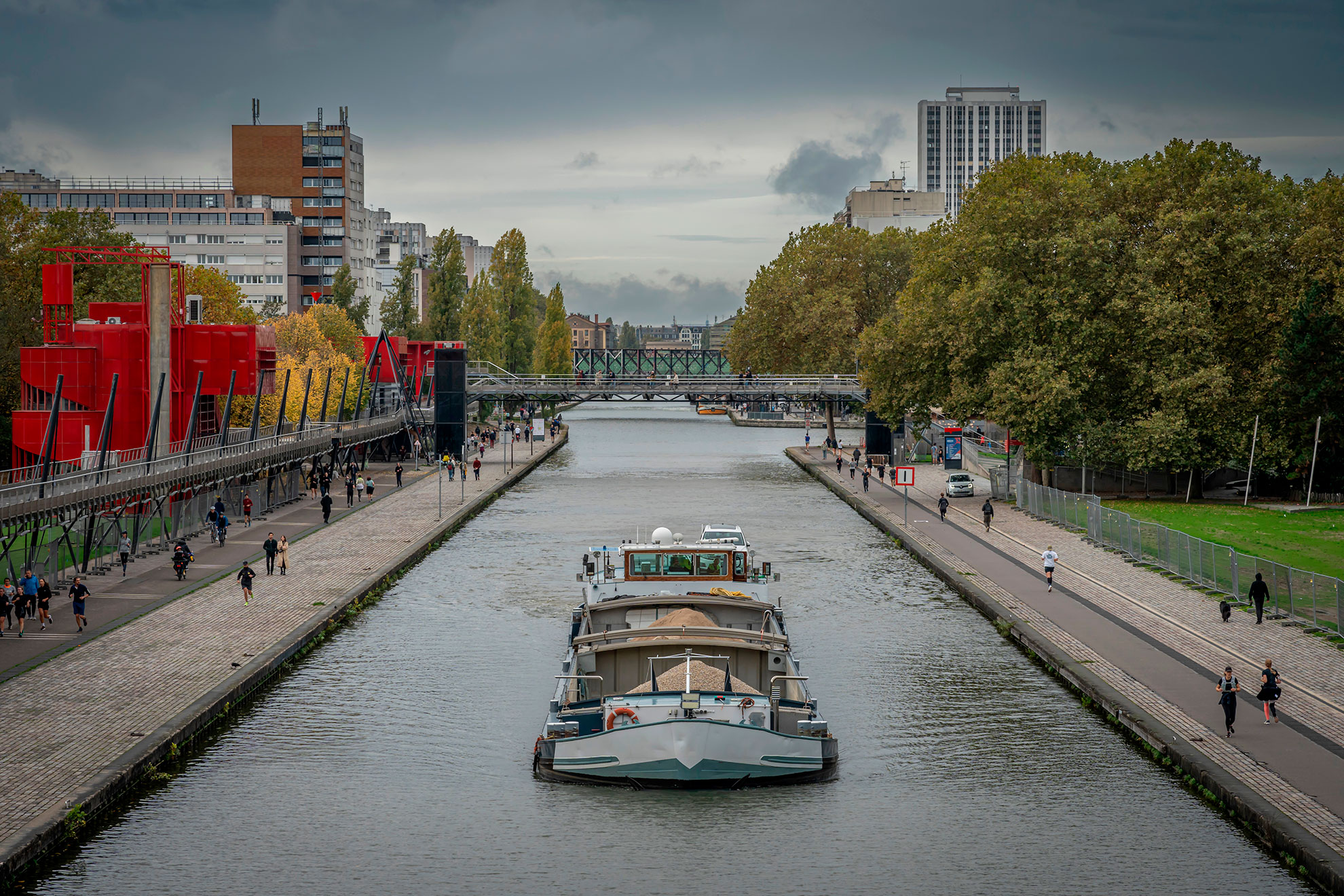View of the Saint-Denis Canal with a barge sailing from the Flander Bridge