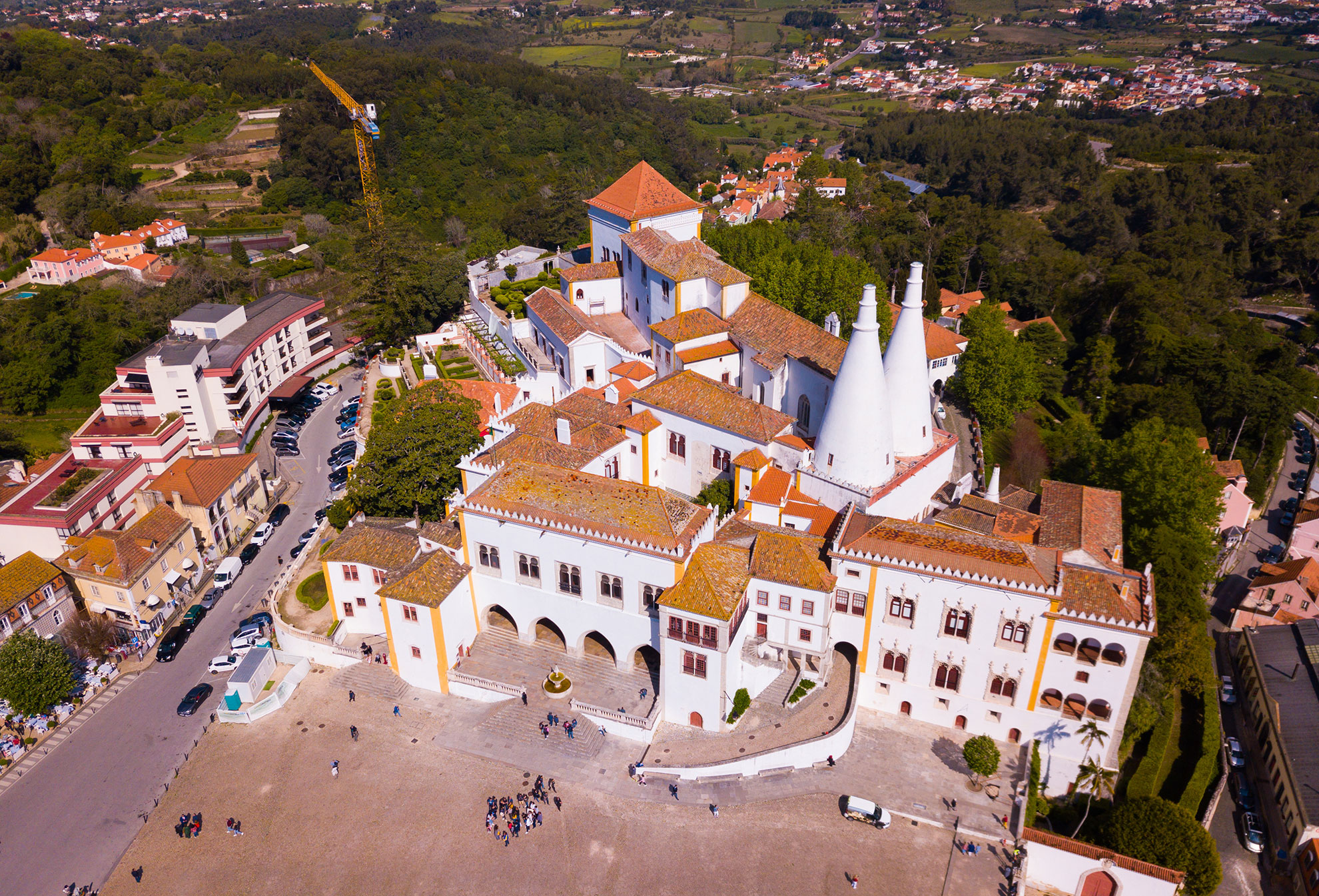 Aerial view of the Palácio Nacional de Sintra with its iconic twin conical chimneys and historic town square, Portugal