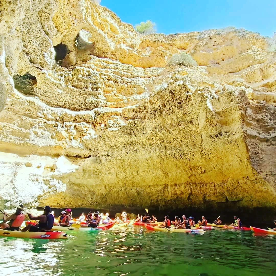 Family kayaking together near Benagil Cave, Algarve — parents and child paddling in turquoise water
