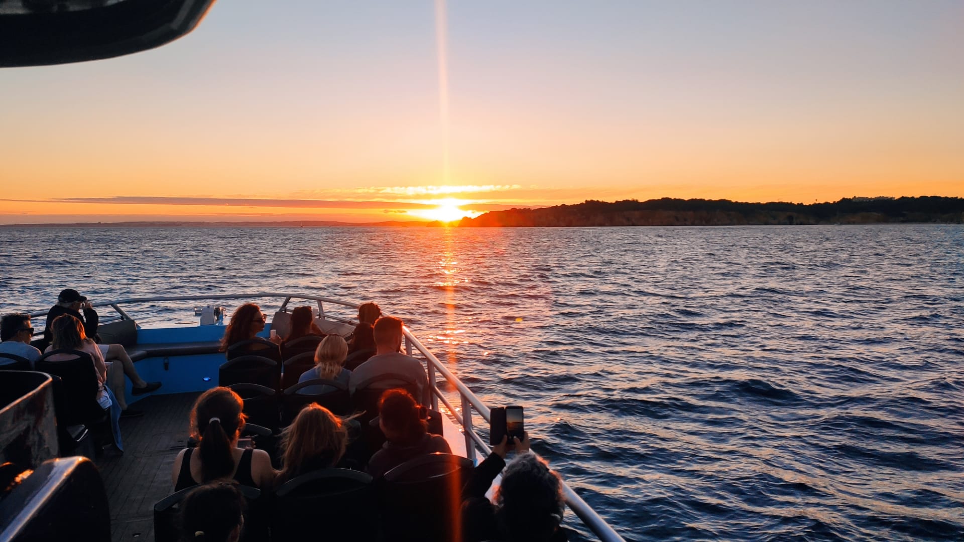 Sunset boat tour departing from Portimão along the Algarve coastline, golden evening light