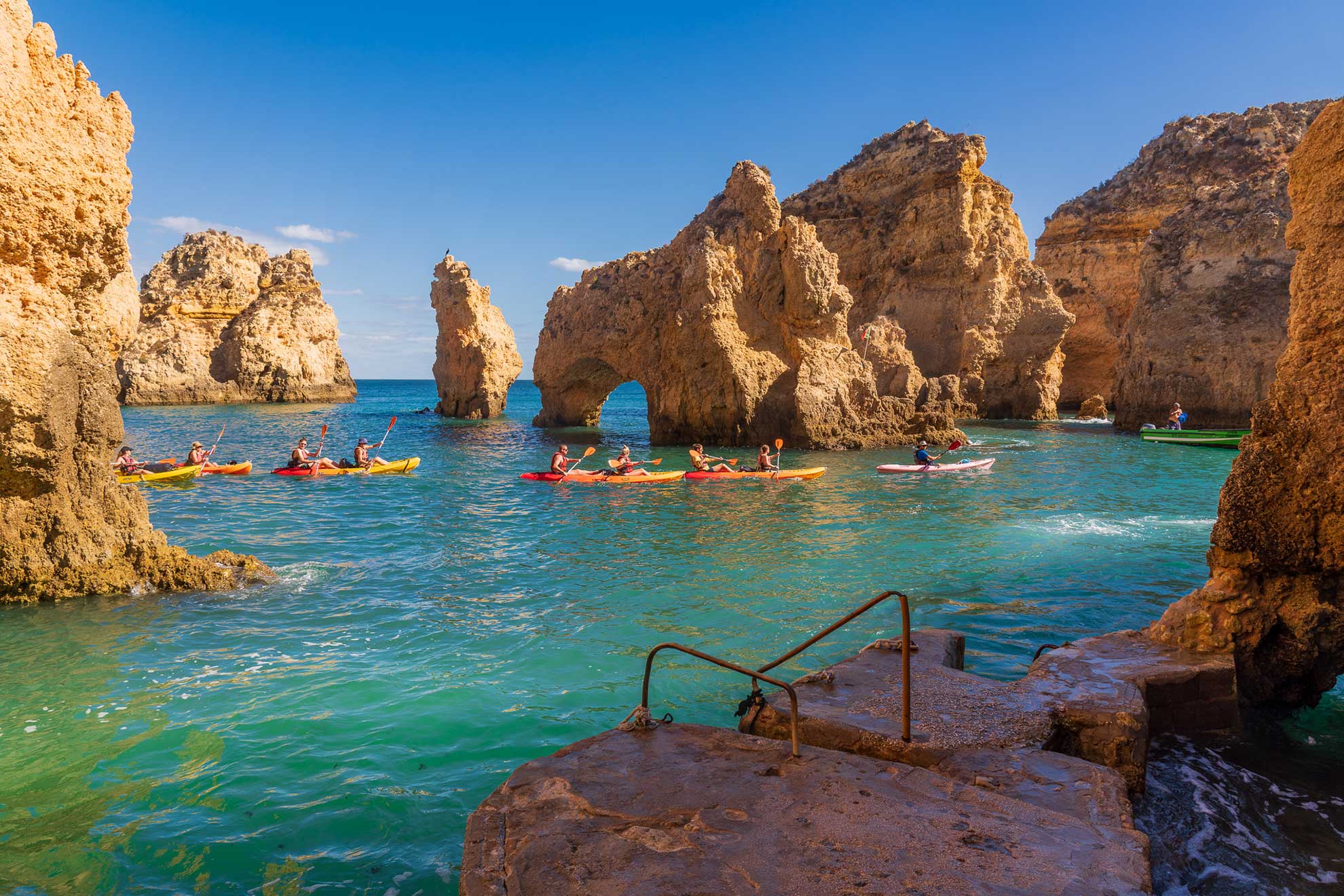 Kayakers paddling through the golden sea caves of Ponta da Piedade, Lagos, Algarve