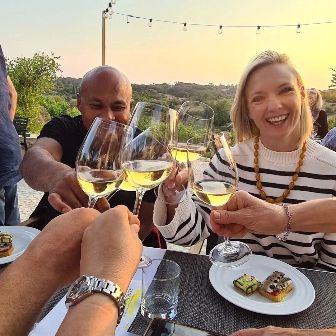 Guided wine tasting at an Algarve winery, guests holding glasses in a cellar