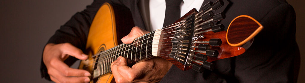Portuguese guitarra player performing in a dimly lit fado house in Mouraria, Lisbon