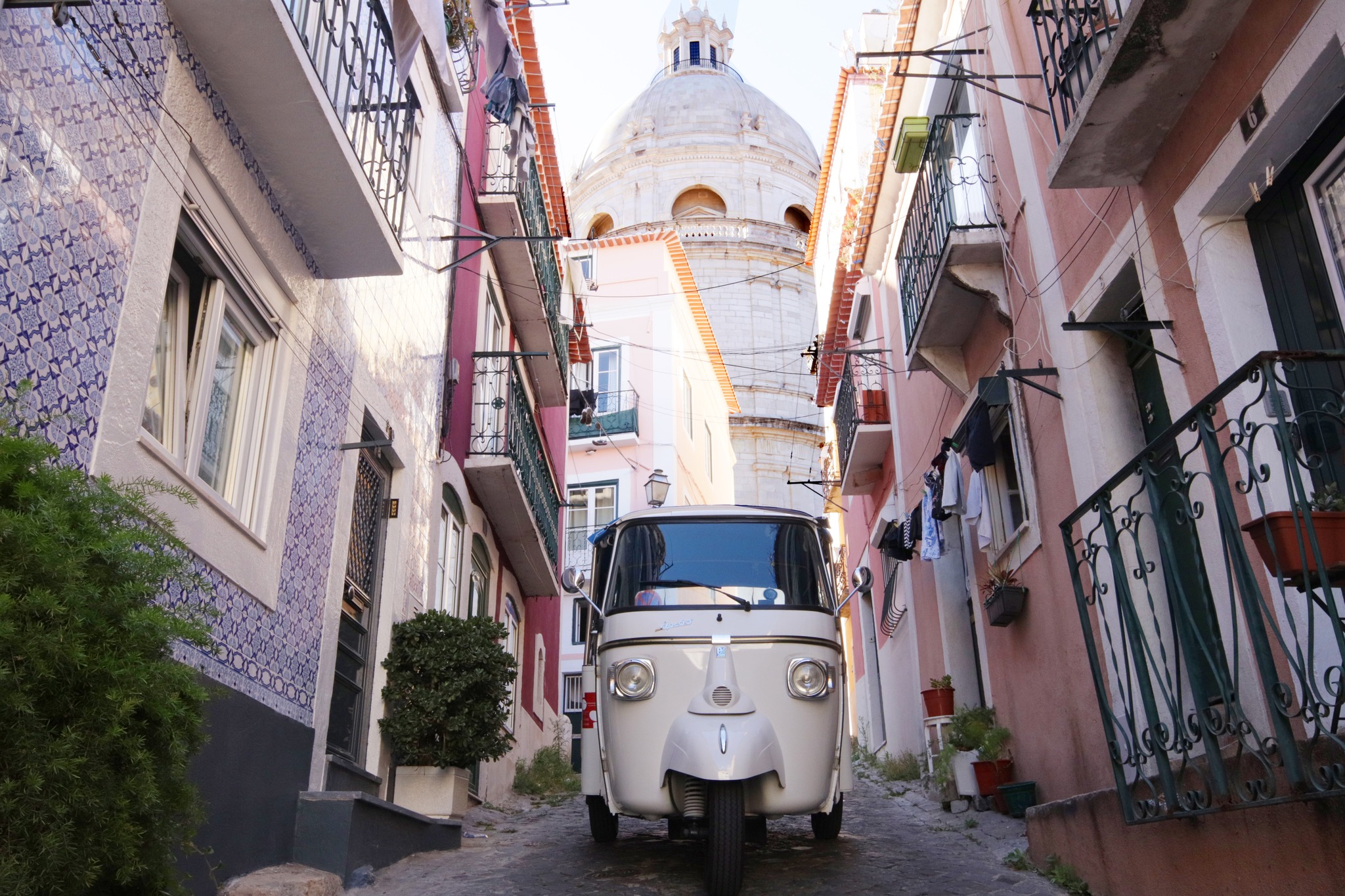 A tuk tuk navigating the narrow cobblestone streets of Alfama, Lisbon