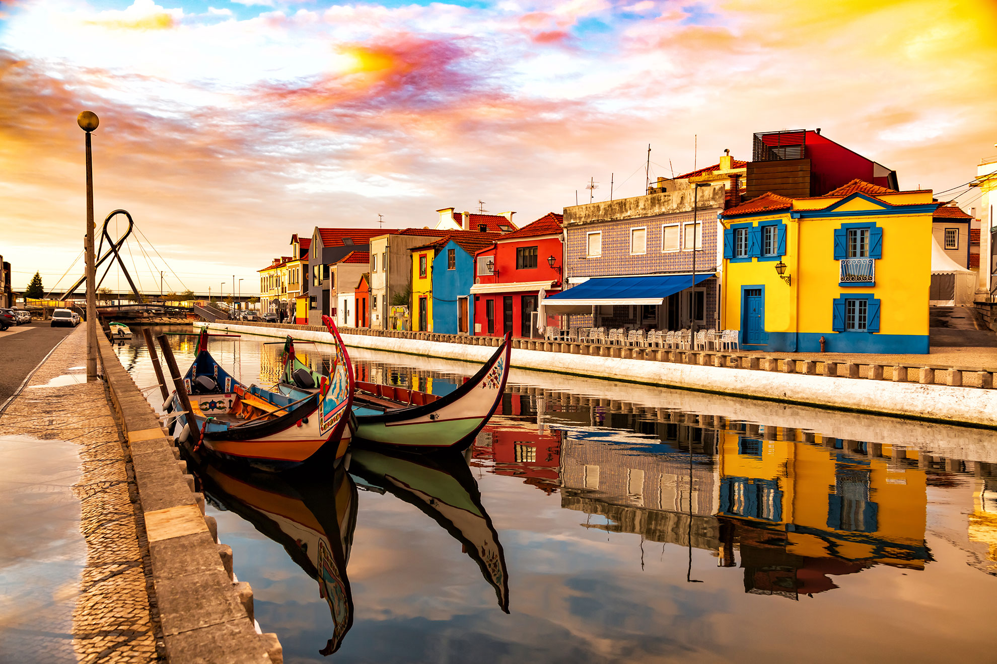 Moliceiro boats moored along the central canal of Aveiro, their prows decorated with hand-painted scenes