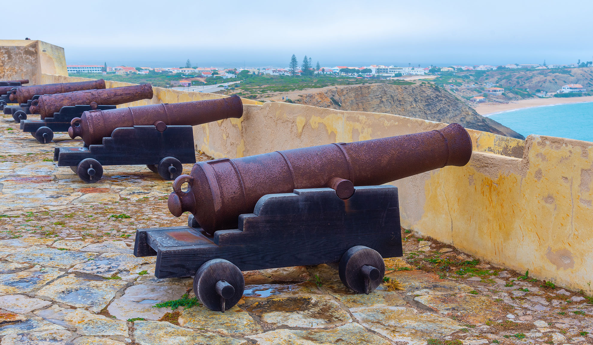 Windswept cliffs of Sagres at dusk with the Atlantic Ocean stretching to the horizon