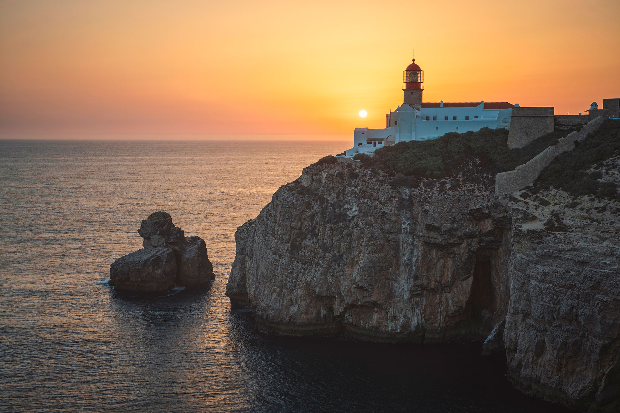Cape St. Vincent lighthouse with Atlantic cliffs at golden hour