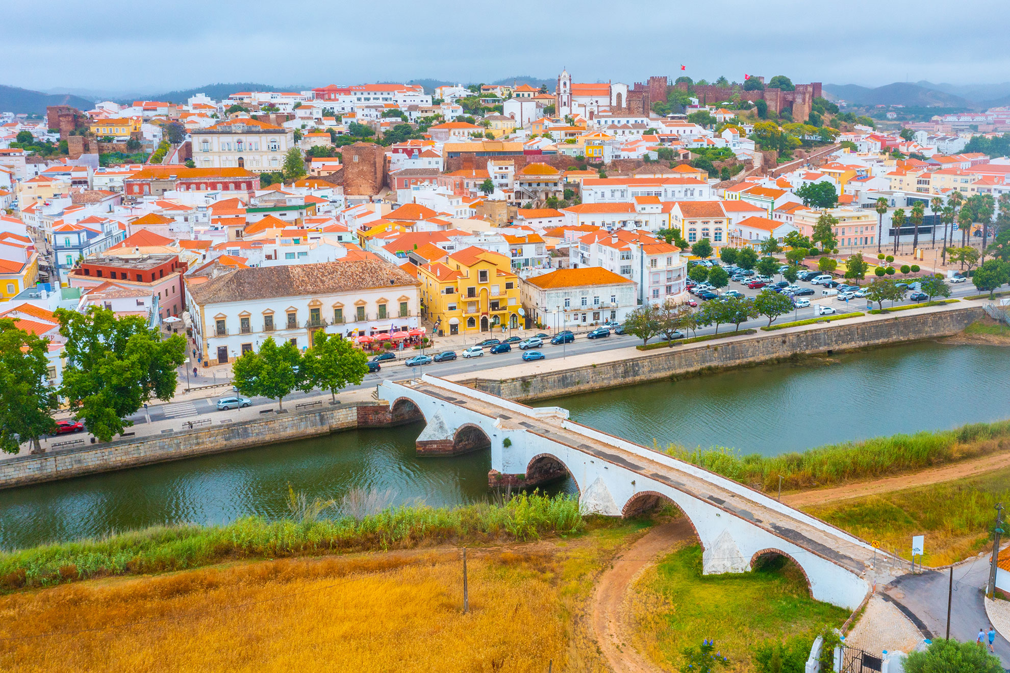 Boat travelling up the Arade River towards Silves with castle in the distance