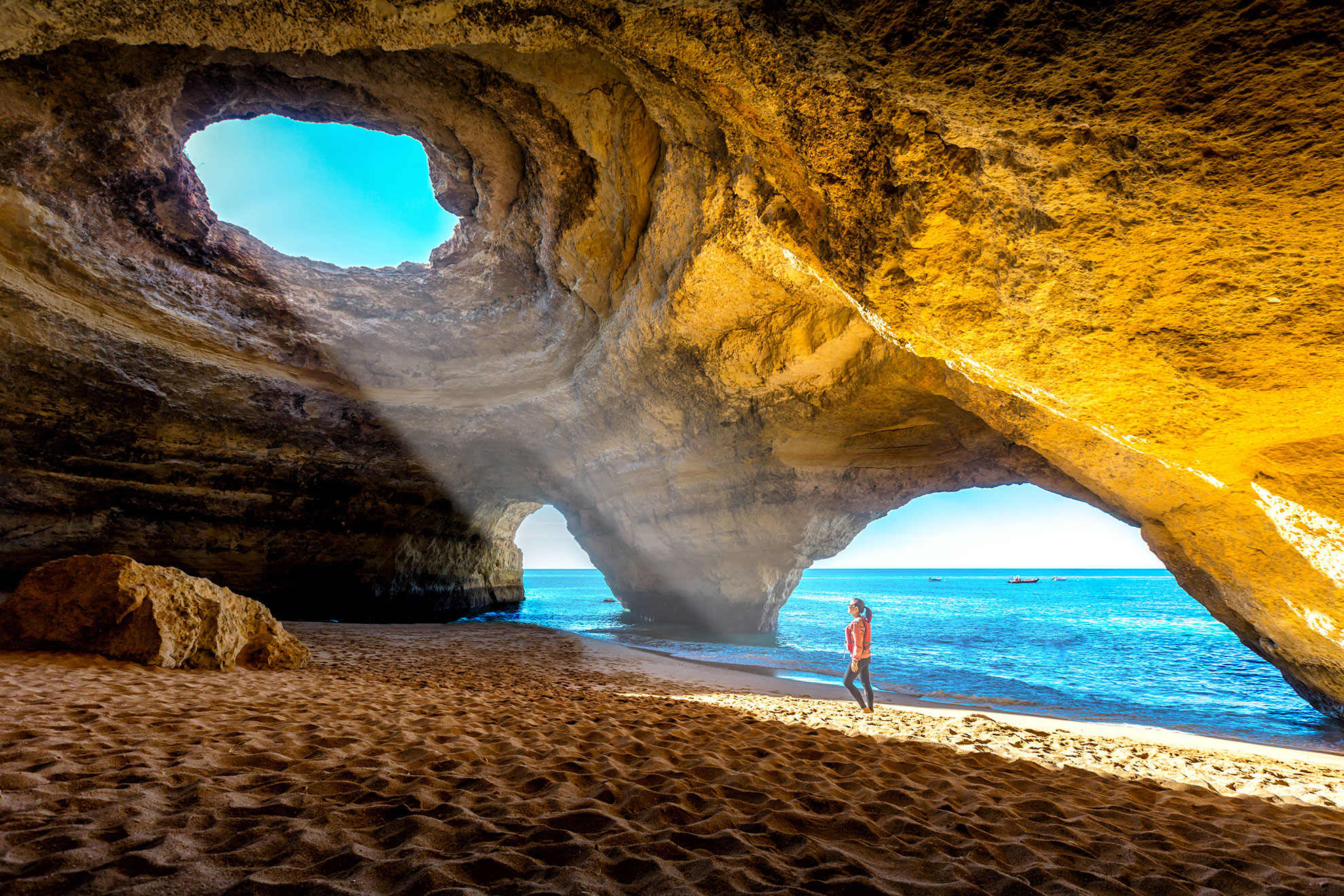 Small boat approaching the famous domed sea cave at Benagil from the ocean entrance