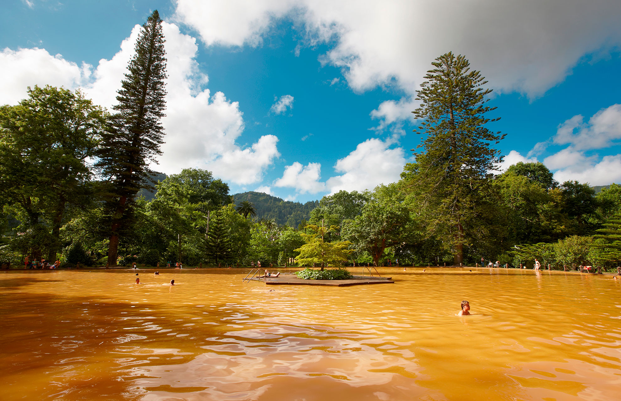 Iron-rich orange thermal pool at Terra Nostra Botanical Garden in Furnas