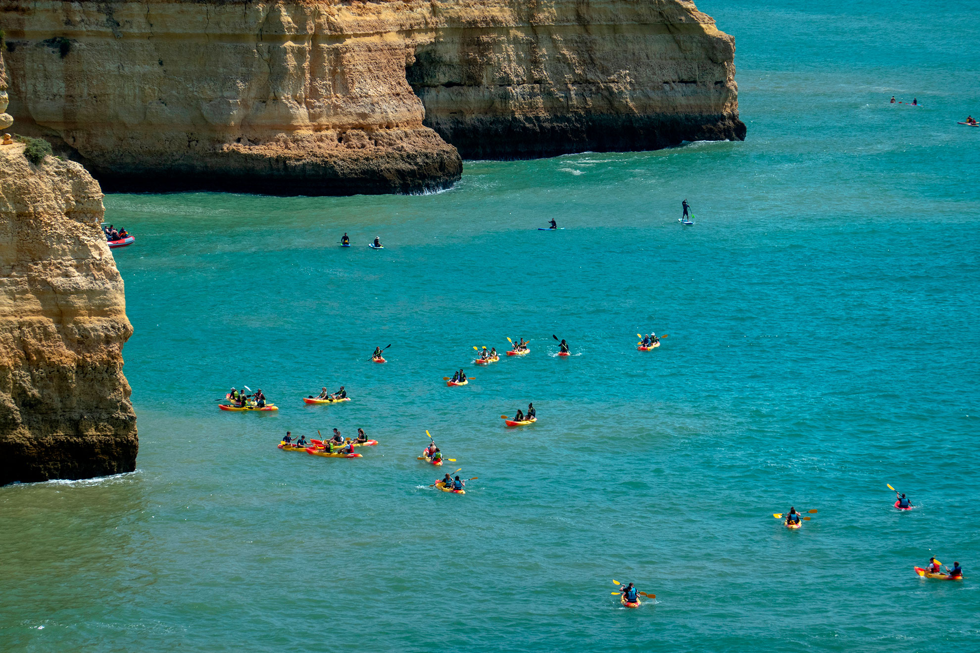 Kayakers approaching the arched sea entrance of Benagil Cave from the Atlantic