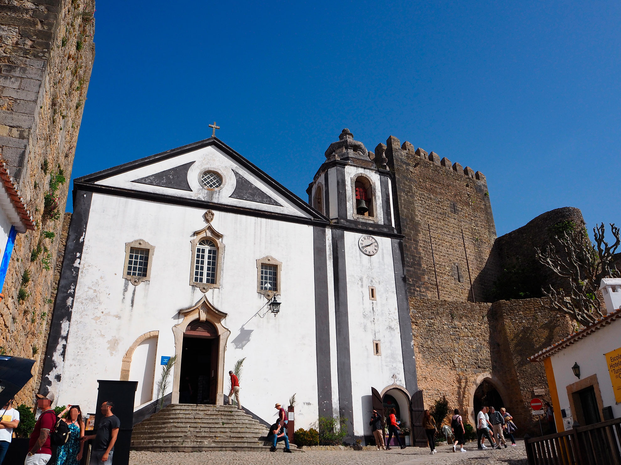 Interior of a converted medieval church in Óbidos now functioning as a bookshop with shelves lining old stone walls